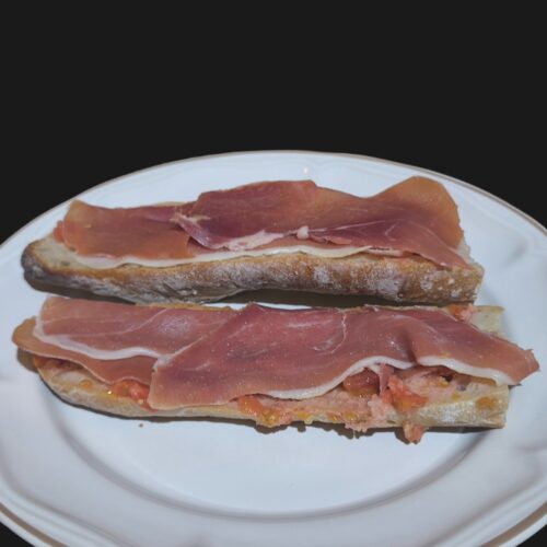 Serrano ham into bread with tomatoes and olive oil